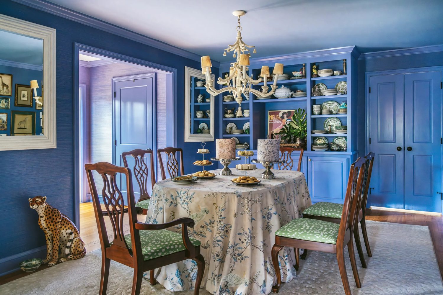 Brunschwig & Fils, La Menagerie : salle à manger bleu cobalt, nappe fleurie et chaises garnies de vert