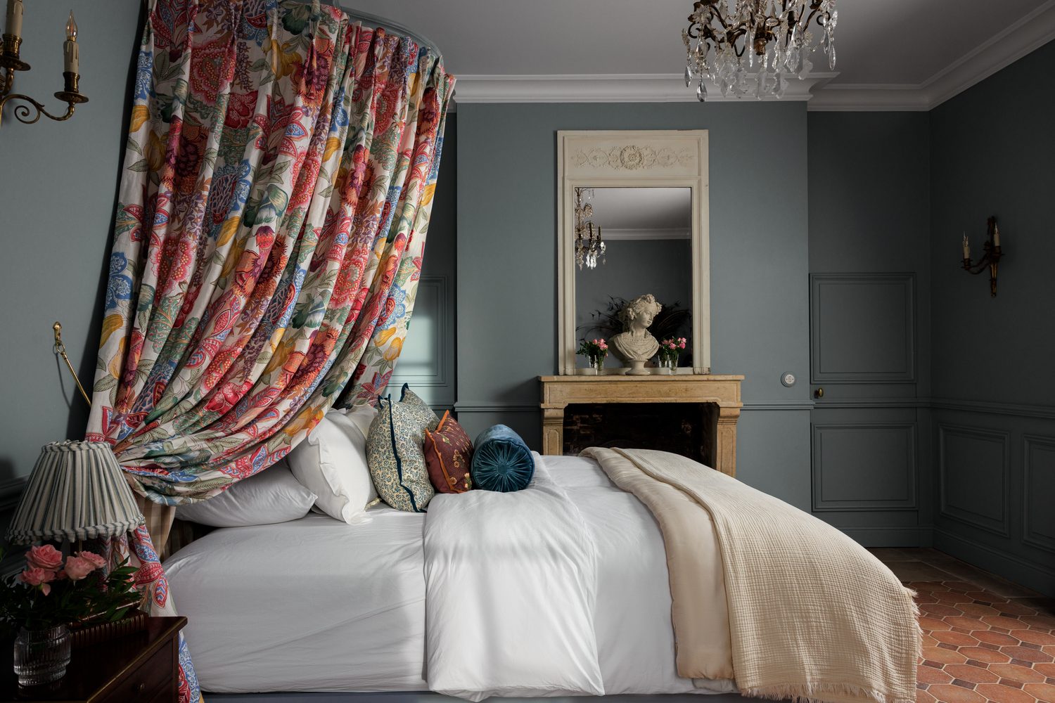 Brunschwig & Fils : lit à ciel de lit fleuri rouge et rose dans une chambre grise