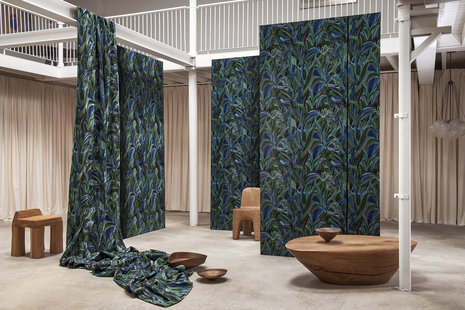 Casamance, Les Précieuses : panneaux de tissu à feuillages bleu-vert suspendus dans un loft