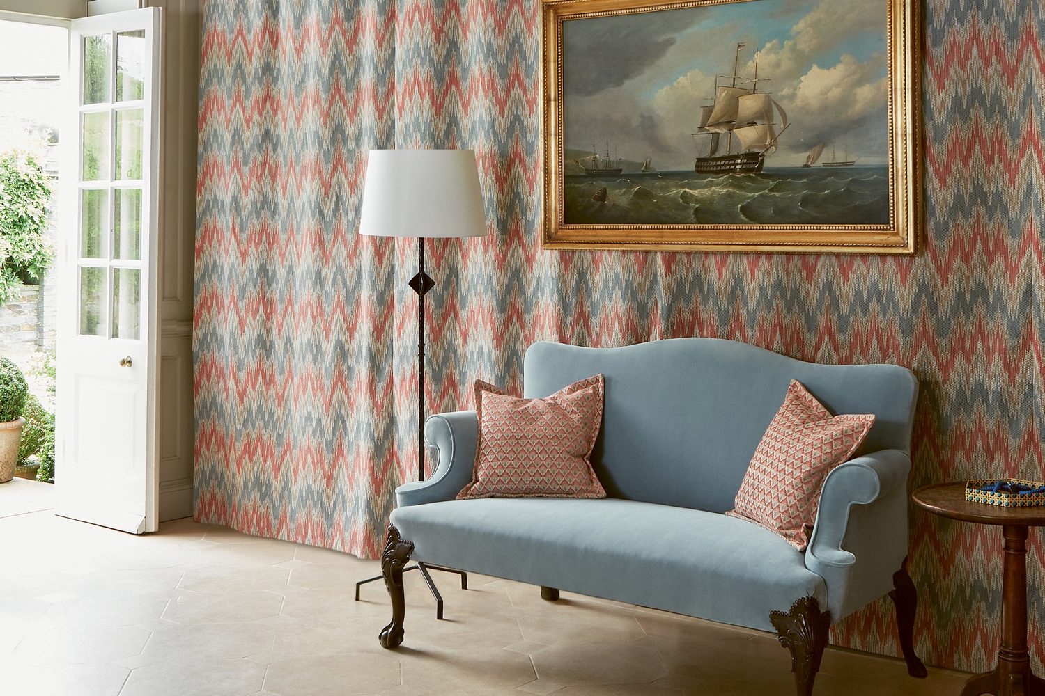 Colefax and Fowler : murs tendus d’un tissu à chevrons corail et bleu, canapé bleu glacier
