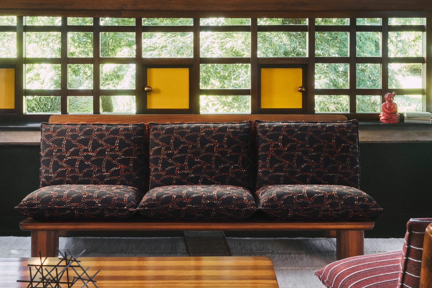 Dominique Kieffer : banquette à motif brun et rouille devant une verrière