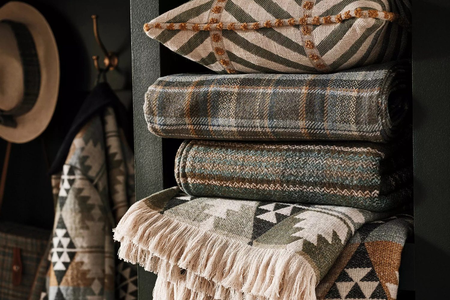 Osborne & Little, Rannoch Wools : plaids écossais et coussins à motifs géométriques empilés