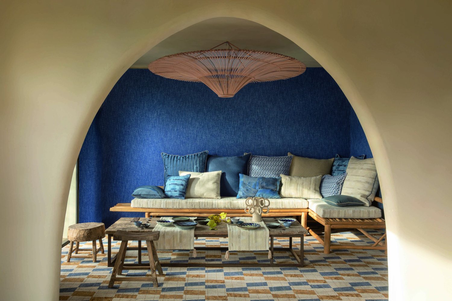 Pierre Frey, Soleil Levant : salon voûté aux murs bleu outremer, banquette garnie de coussins bleus
