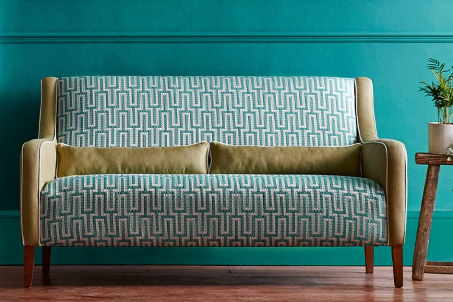 Sanderson, Linnean Weaves : banquette à motif géométrique turquoise devant un mur bleu canard