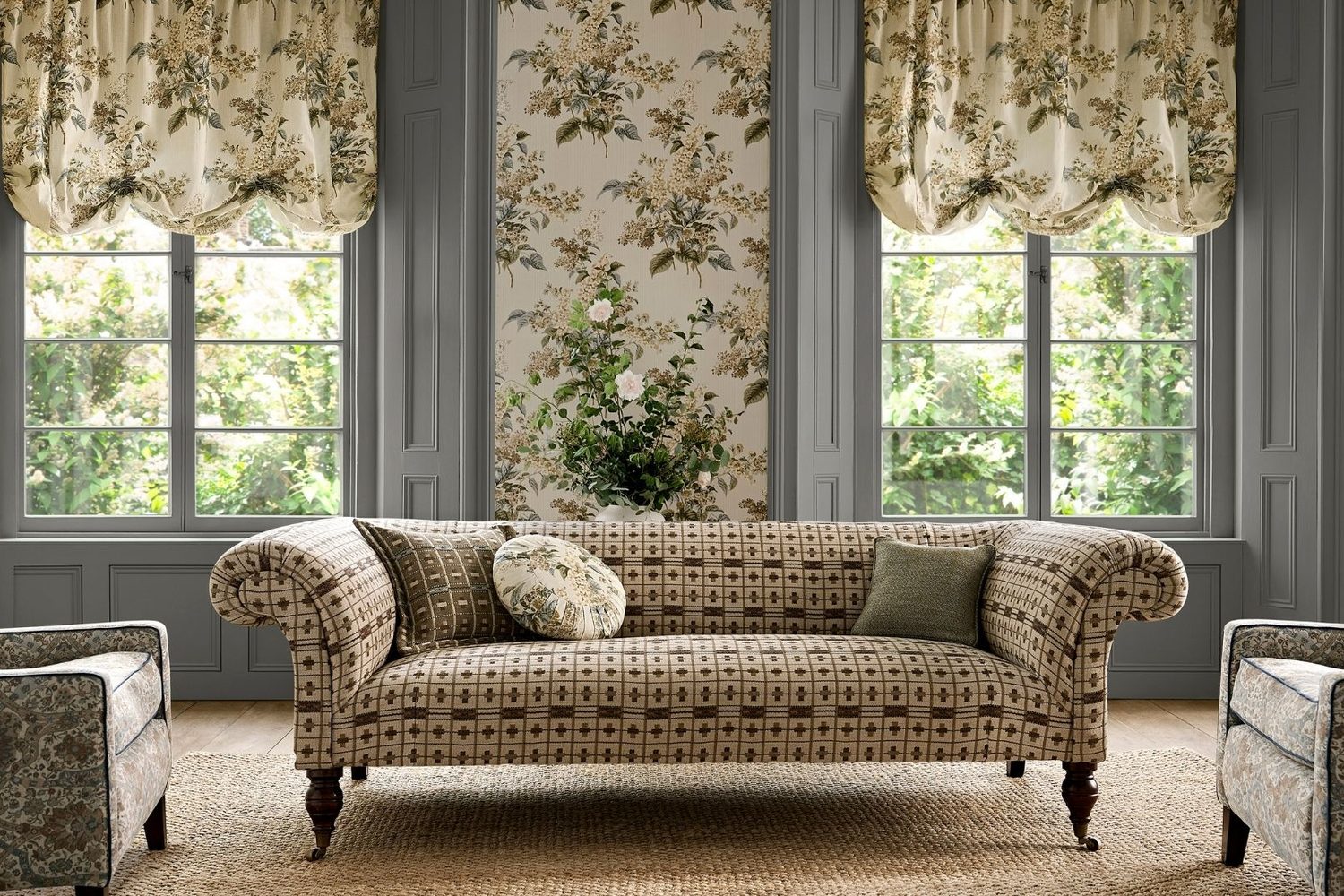 Sanderson, Highgrove : canapé Chesterfield à petits carreaux sous des stores bouillonnés fleuris